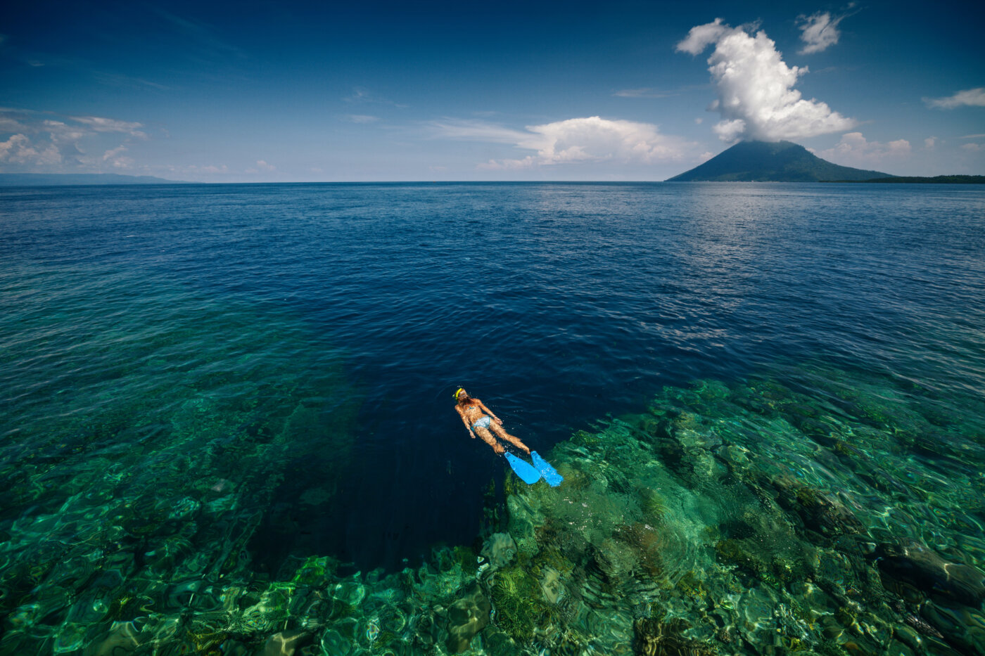 Lady snorkeling over reef wall